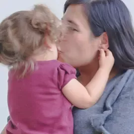 Mother kissing daughter